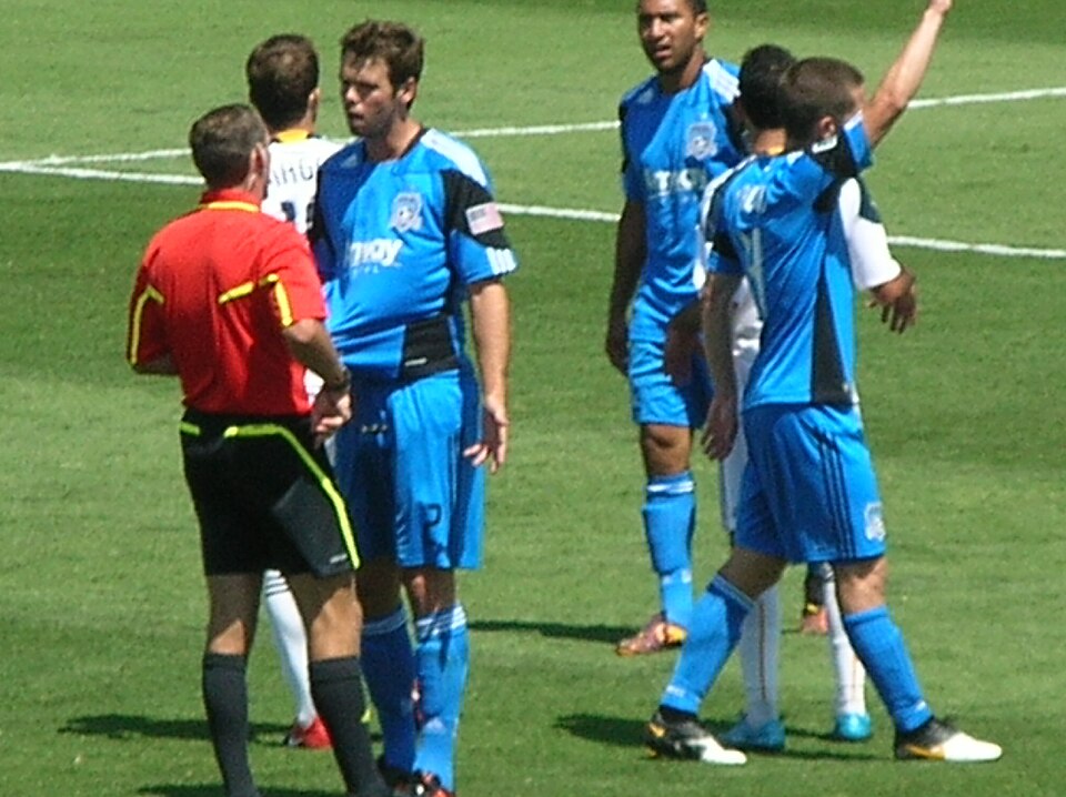 Jugador recibiendo tarjeta amarilla en un partido de fútbol